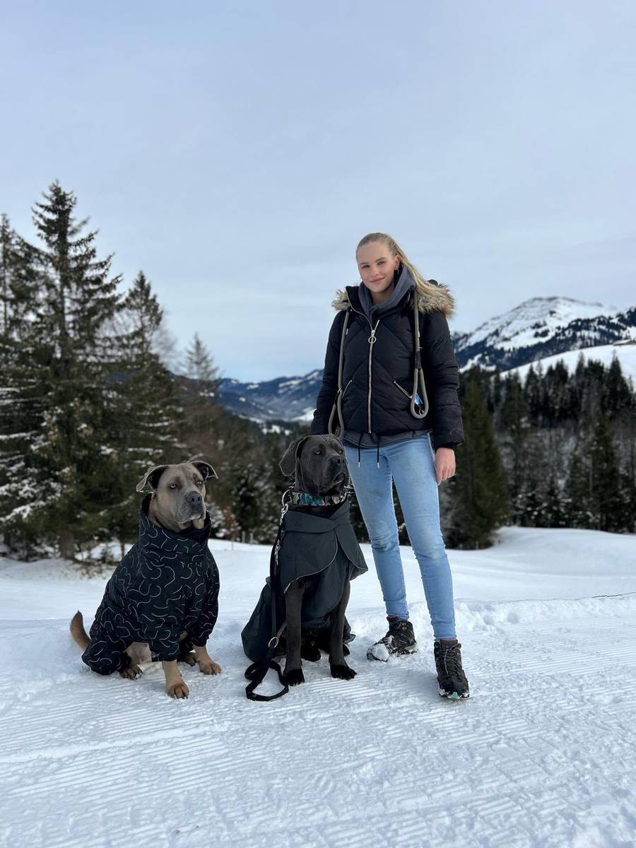 Samantha mit zwei Hunden in winterlicher Berglandschaft